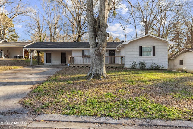 ranch-style house with a deck, an attached carport, brick siding, driveway, and a front yard