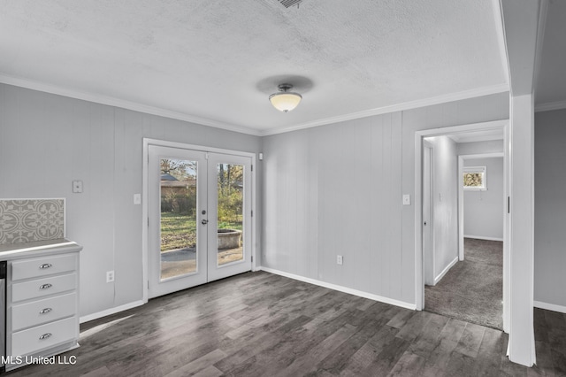 unfurnished dining area with a textured ceiling, dark wood-type flooring, baseboards, french doors, and crown molding