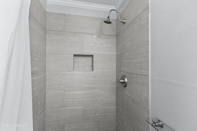 bathroom featuring ornamental molding and tiled shower