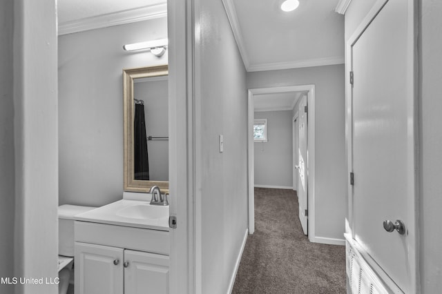 bathroom with baseboards, ornamental molding, and vanity