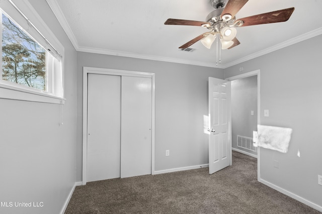 unfurnished bedroom featuring ornamental molding, a closet, carpet flooring, and visible vents