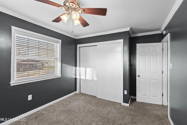 unfurnished bedroom with carpet floors, a closet, crown molding, and baseboards