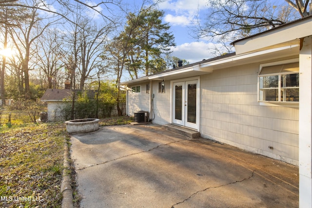 view of patio / terrace with cooling unit, french doors, fence, and an outdoor fire pit