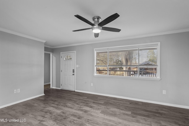 interior space with ornamental molding, wood finished floors, a ceiling fan, and baseboards