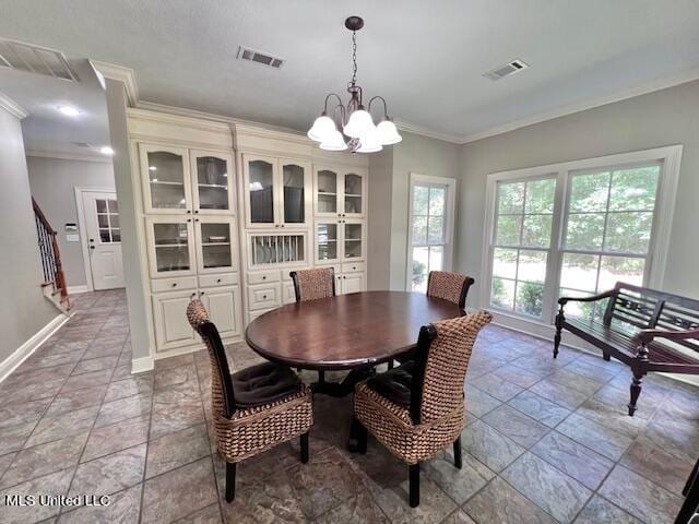 dining space featuring crown molding and a chandelier