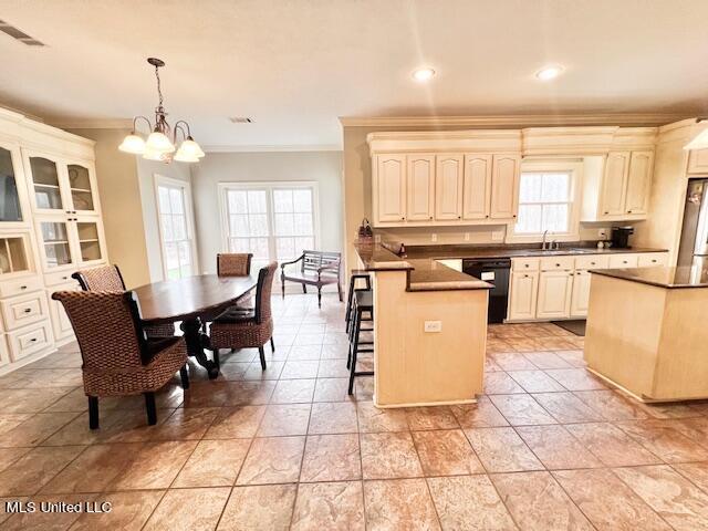 kitchen with pendant lighting, ornamental molding, dishwasher, and cream cabinets