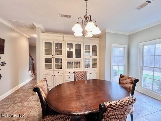 dining space with ornamental molding and a notable chandelier