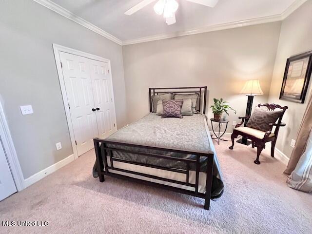 carpeted bedroom featuring ornamental molding and ceiling fan