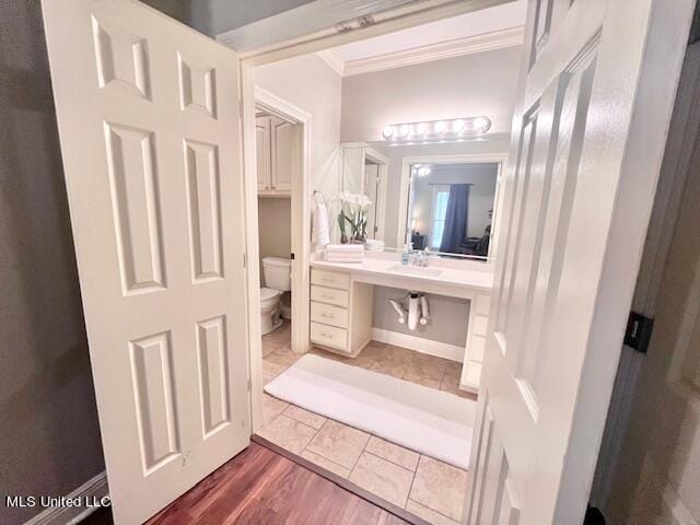 bathroom featuring ornamental molding, toilet, hardwood / wood-style floors, and vanity