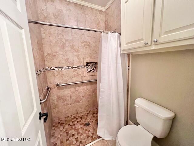 bathroom with ornamental molding, toilet, tile patterned flooring, and a shower with shower curtain