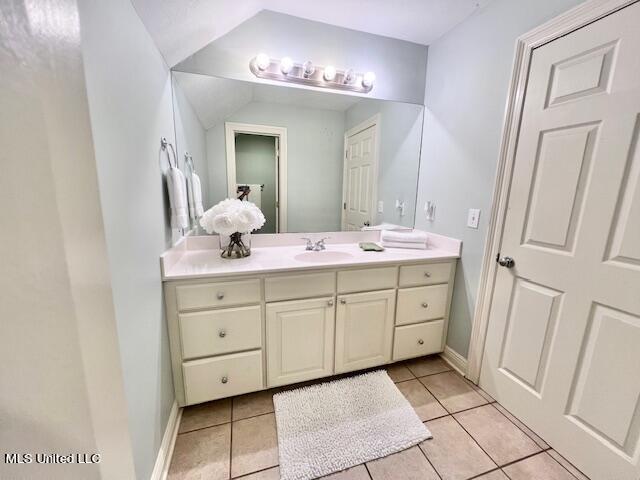 bathroom featuring vaulted ceiling, vanity, and tile patterned flooring