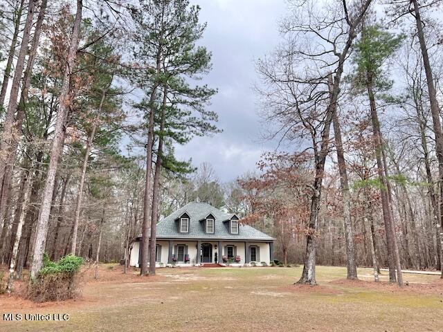 cape cod house with a porch and a front yard