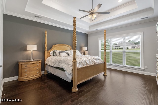 bedroom featuring a raised ceiling, ornamental molding, visible vents, and dark wood-type flooring
