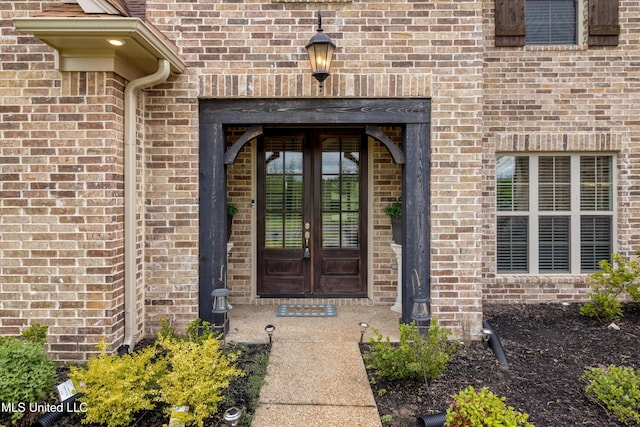 doorway to property featuring french doors and brick siding