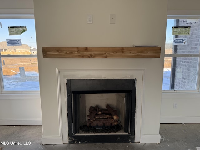 interior details with concrete floors, a fireplace, and baseboards