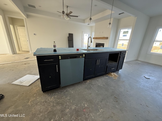 kitchen with a tray ceiling, stainless steel dishwasher, a sink, and dark cabinets