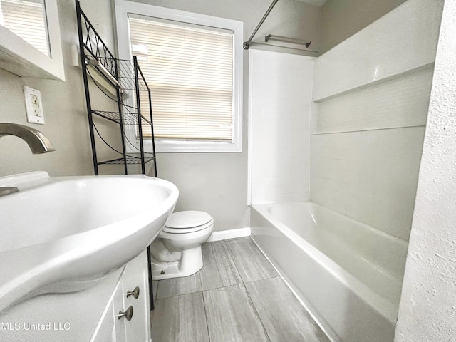 full bathroom with shower / bathing tub combination, a wealth of natural light, sink, and toilet