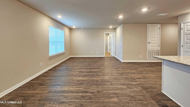 empty room with recessed lighting, baseboards, and dark wood-style floors