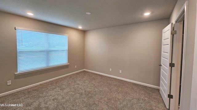 empty room with carpet floors, recessed lighting, and baseboards