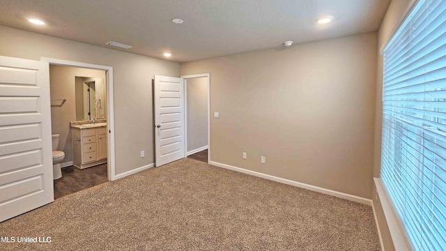 unfurnished bedroom featuring recessed lighting, baseboards, dark colored carpet, and visible vents