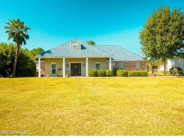 view of front of house featuring a shingled roof and a front yard