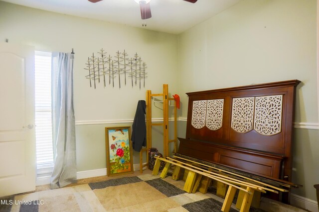 sitting room with baseboards, a ceiling fan, and carpet