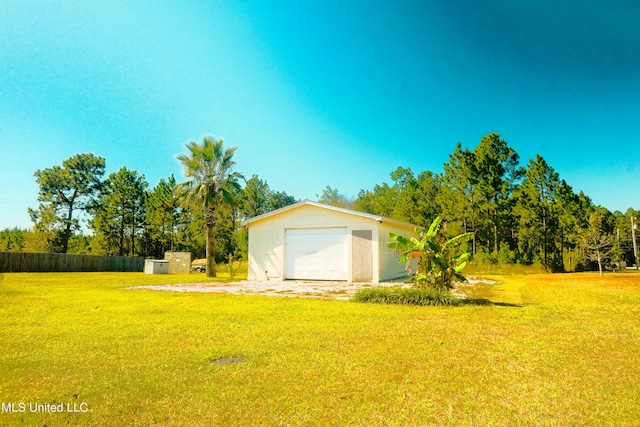 view of yard with fence, an outbuilding, and a garage