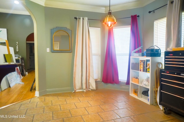 interior space with arched walkways, a wealth of natural light, and ornamental molding