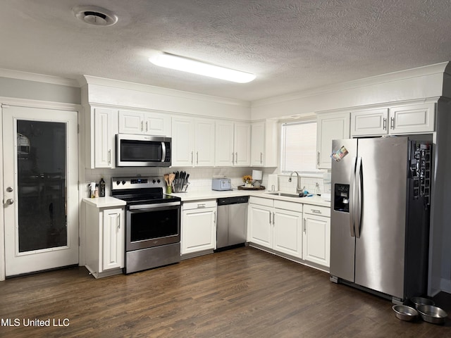 5064 Old Canton Rd, Jackson, MS 39211 - kitchen featuring a sink, light countertops, dark wood-type flooring, appliances with stainless steel finishes, and white cabinetry