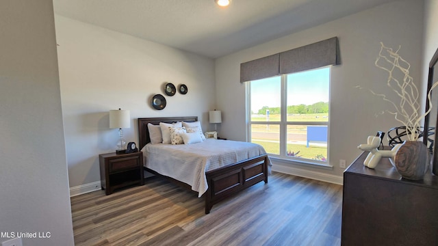 bedroom with dark hardwood / wood-style flooring