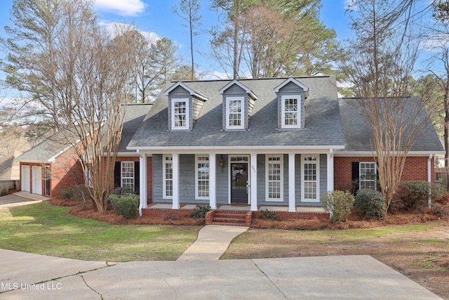 cape cod-style house with brick siding, covered porch, and a shingled roof