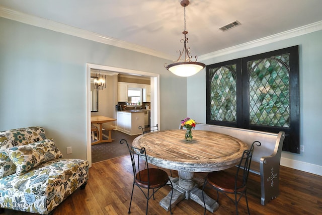 dining room with visible vents, dark wood-type flooring, baseboards, and ornamental molding