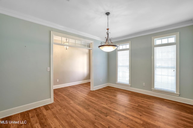 unfurnished room with crown molding, wood finished floors, and baseboards