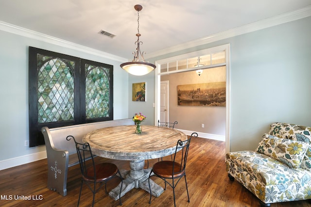 dining room featuring crown molding, wood finished floors, visible vents, and baseboards