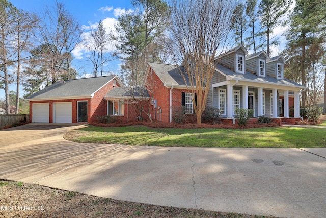 cape cod-style house with a front lawn, a porch, concrete driveway, and an attached garage