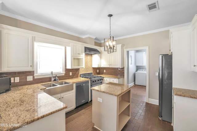 kitchen featuring ventilation hood, visible vents, washer / dryer, a sink, and appliances with stainless steel finishes