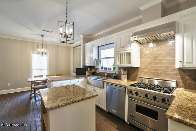 kitchen with a sink, stainless steel appliances, a notable chandelier, and decorative backsplash