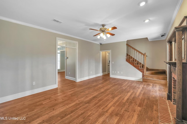 unfurnished living room with visible vents, crown molding, a ceiling fan, and stairway