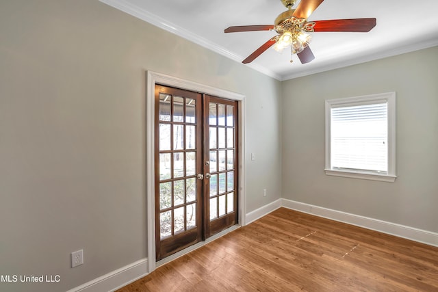 spare room with a healthy amount of sunlight, crown molding, and wood finished floors