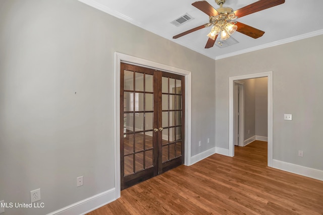 unfurnished room with visible vents, baseboards, french doors, wood finished floors, and a ceiling fan