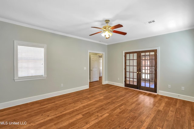 spare room featuring a ceiling fan, wood finished floors, visible vents, ornamental molding, and french doors