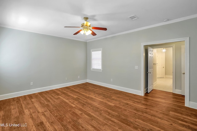 empty room with visible vents, crown molding, a ceiling fan, and wood finished floors