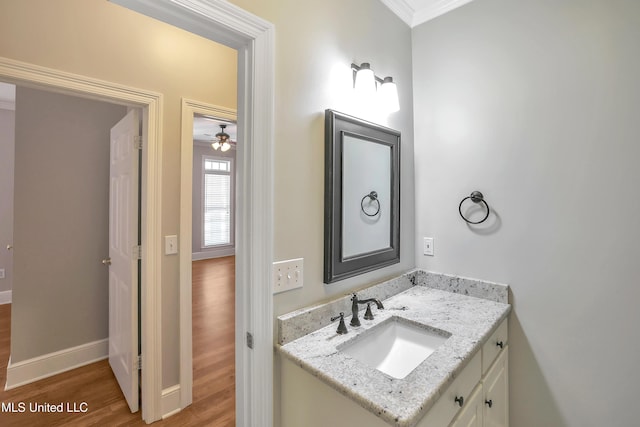 bathroom with vanity, wood finished floors, baseboards, and a ceiling fan