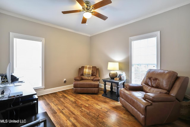 living area with hardwood / wood-style flooring, crown molding, baseboards, and ceiling fan