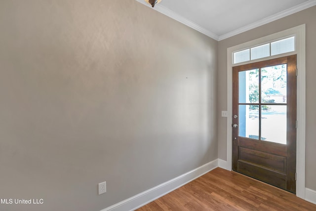 interior space featuring baseboards, wood finished floors, and crown molding