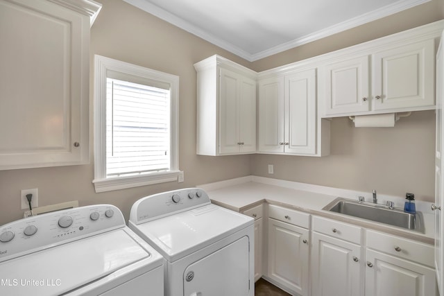 washroom featuring a sink, cabinet space, crown molding, and washer and clothes dryer