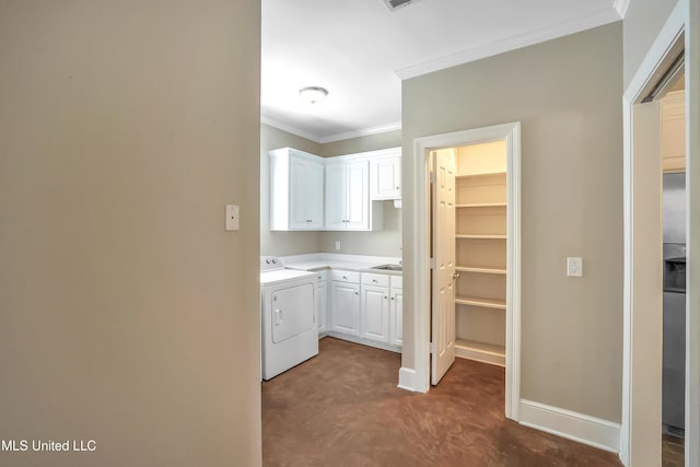 clothes washing area with washer / dryer, crown molding, cabinet space, and baseboards