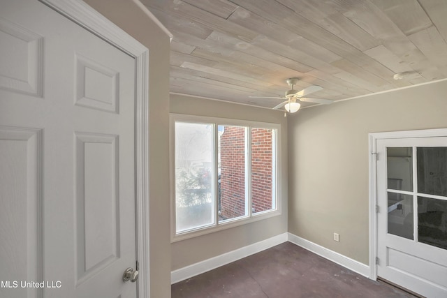 unfurnished room with baseboards, concrete flooring, wood ceiling, and a ceiling fan