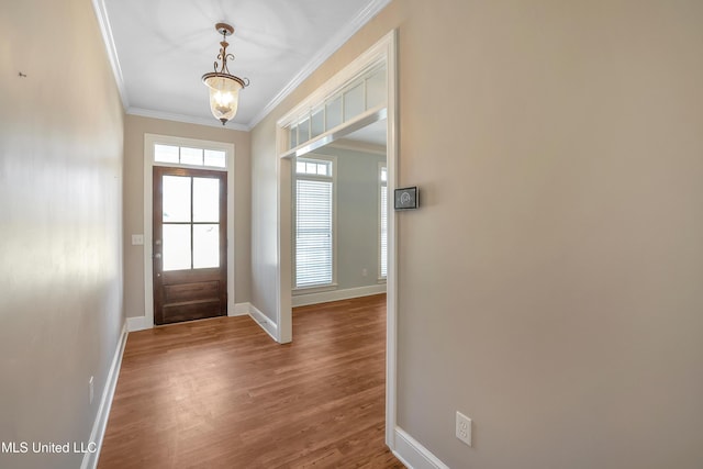 entryway with a chandelier, wood finished floors, baseboards, and ornamental molding