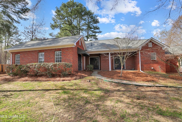 view of front of home featuring brick siding and a front lawn